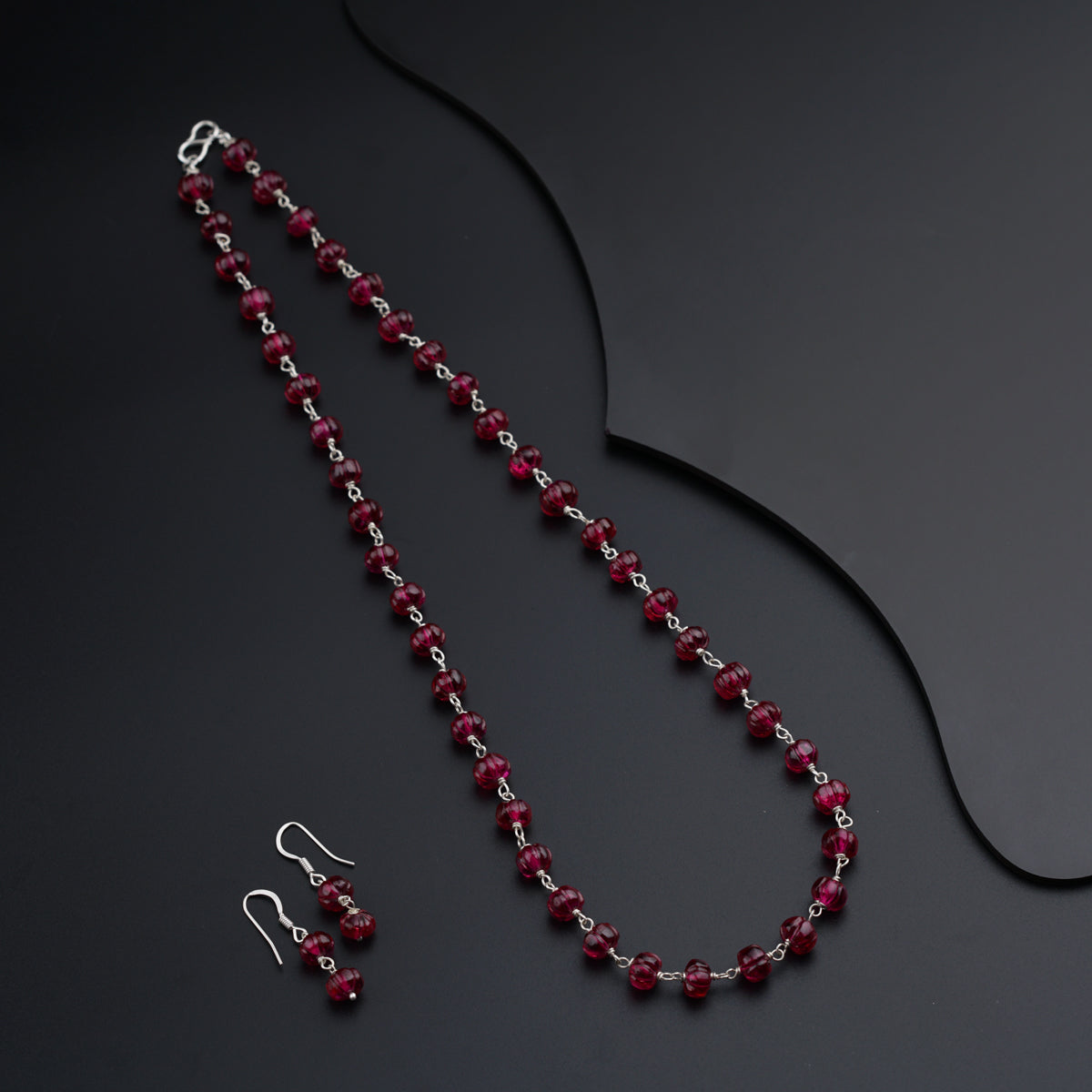 a necklace and earring set with red beads