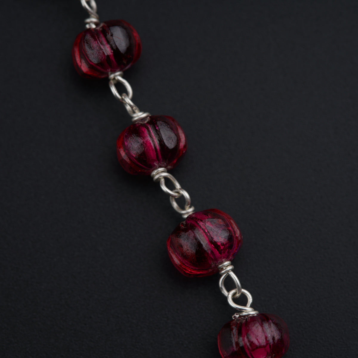 a close up of a bracelet with red beads