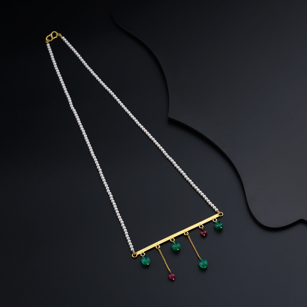 a necklace with a bar and beads hanging from it