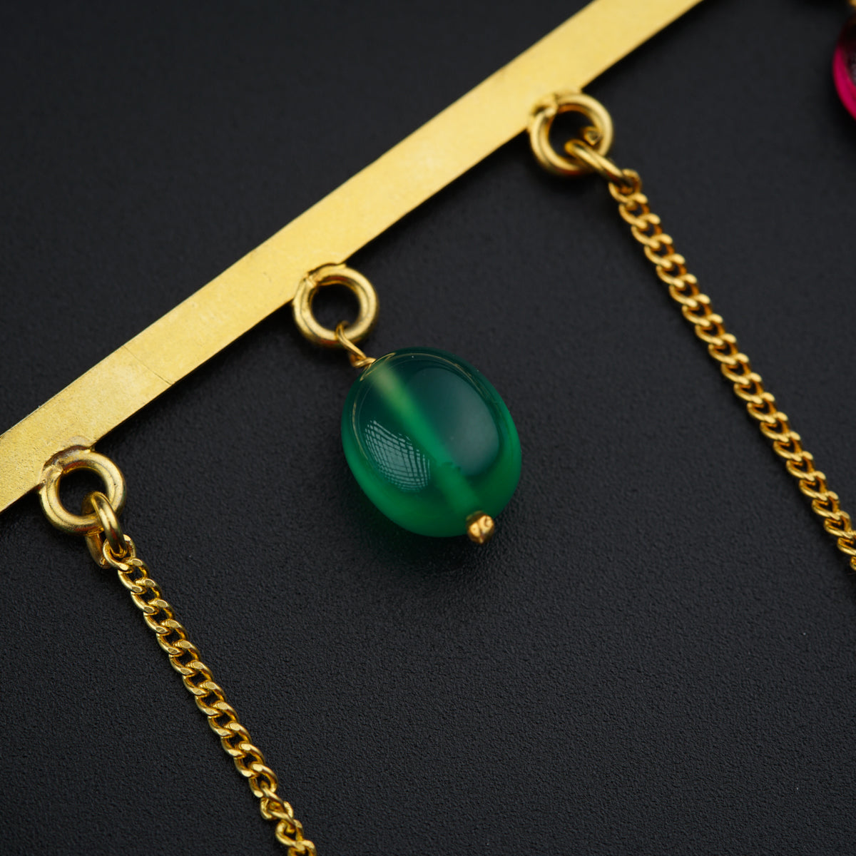 a close up of a chain with a green ball on it