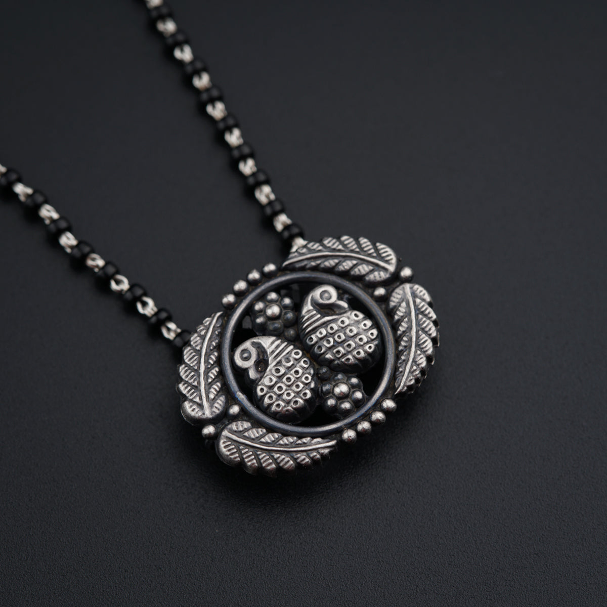 a black necklace with two owls on it
