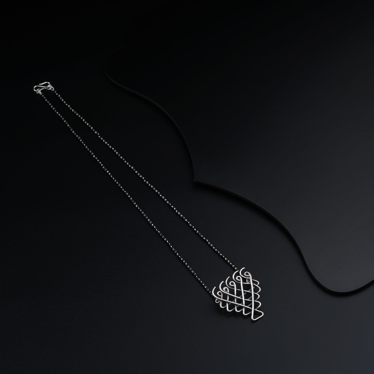 a necklace with a heart on a black background