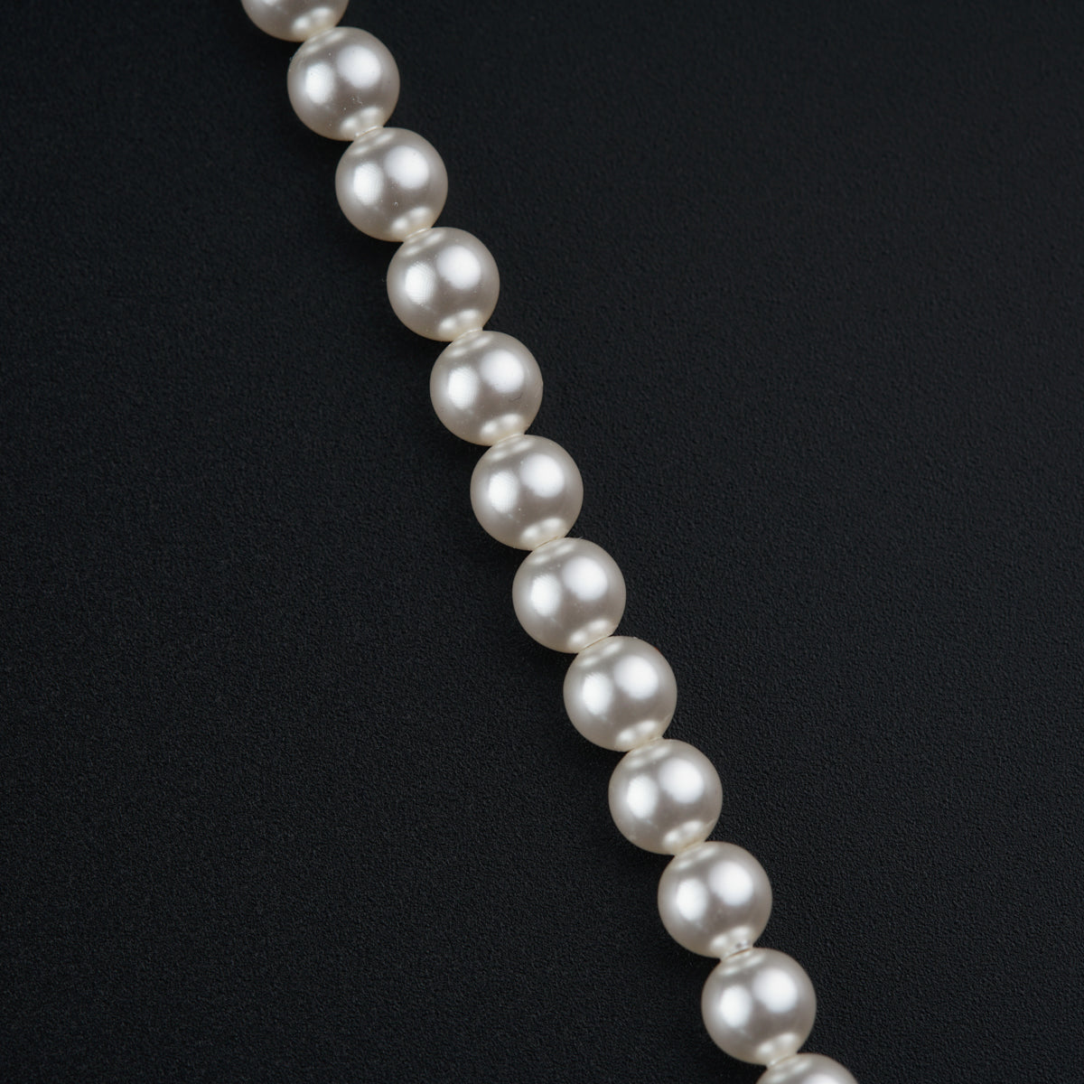 a white pearl necklace on a black background