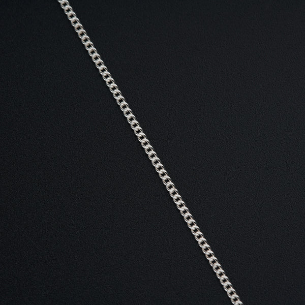 a silver chain is shown on a black surface