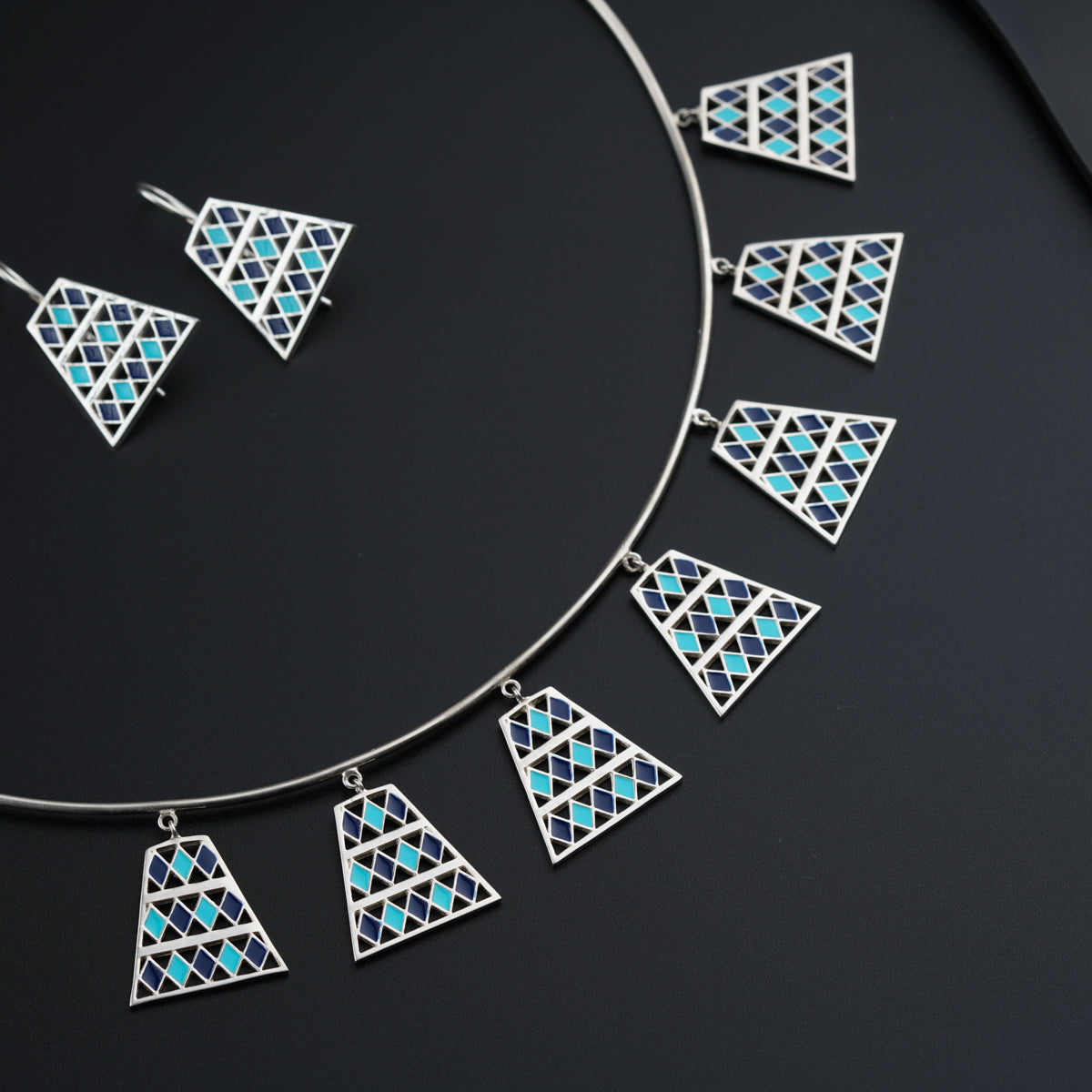 a necklace and earring set with blue and white triangles