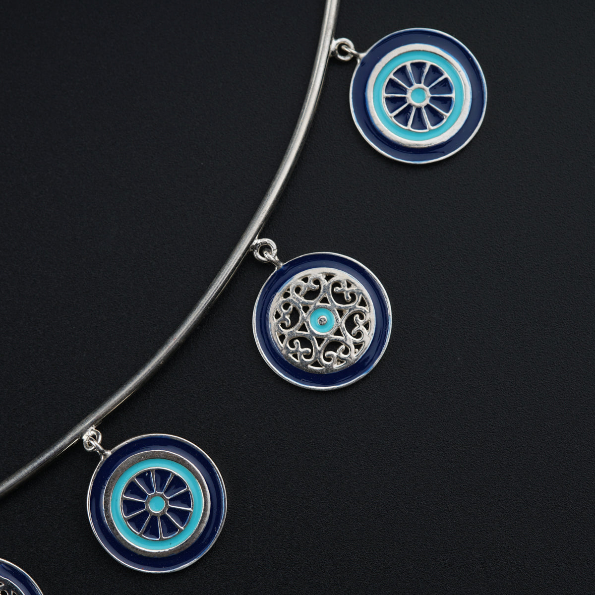 a silver necklace with blue and white designs on it