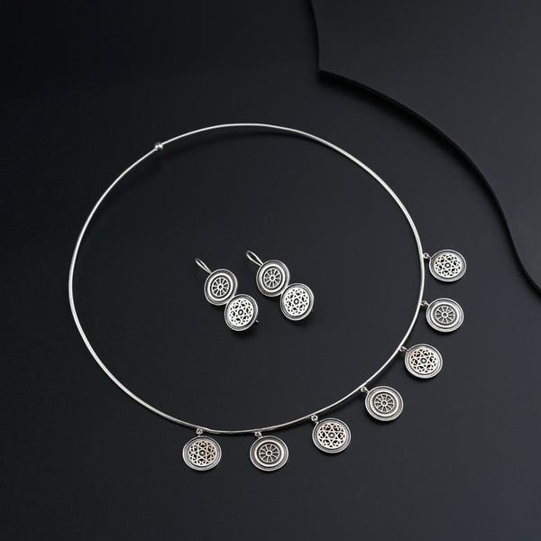 a necklace and earring set on a black surface
