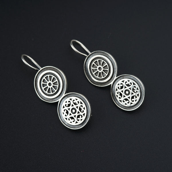 a pair of earrings sitting on top of a table