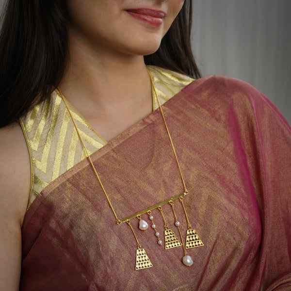 a woman wearing a gold and white necklace