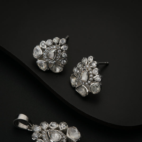 Close-up of silver Polki earrings and pendant with moissanite for party wear