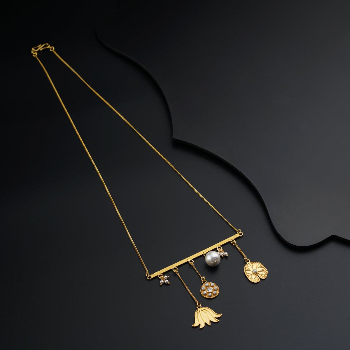 a gold necklace with pearls and a pendant