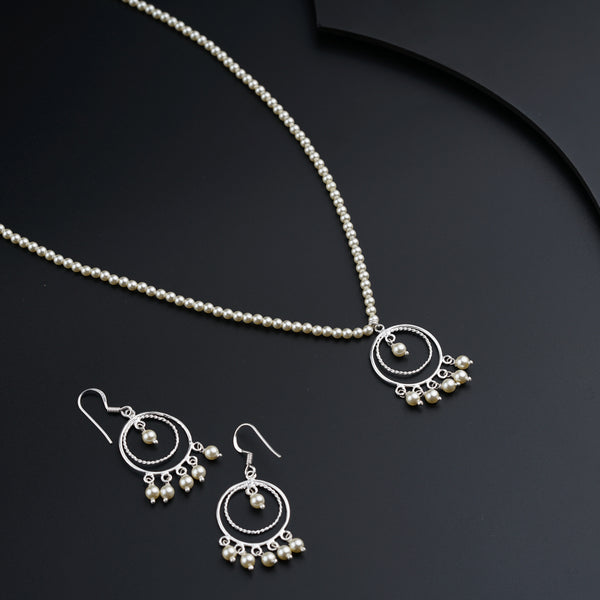 a necklace and earrings on a black surface