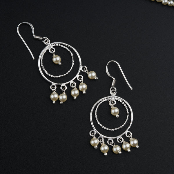a pair of earrings with pearls hanging from them