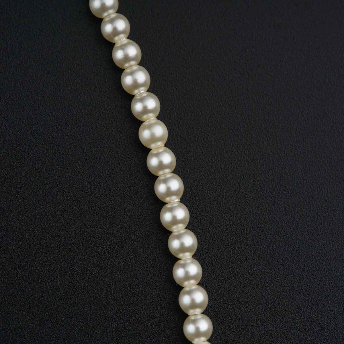 a necklace of pearls on a black background