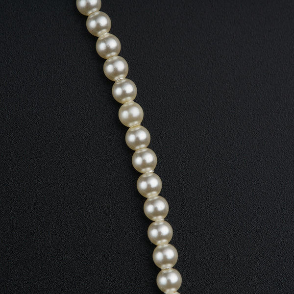 a necklace of pearls on a black background