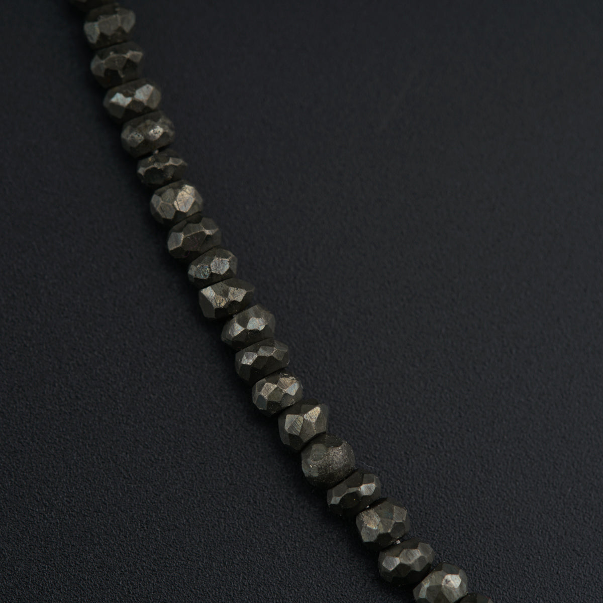 a black diamond necklace on a black surface