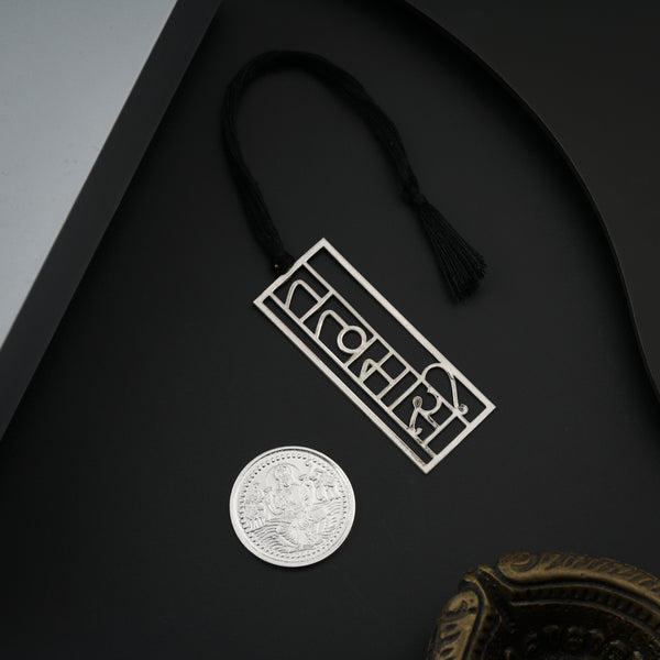 Silver coin and bookmark with black tassels in gift box