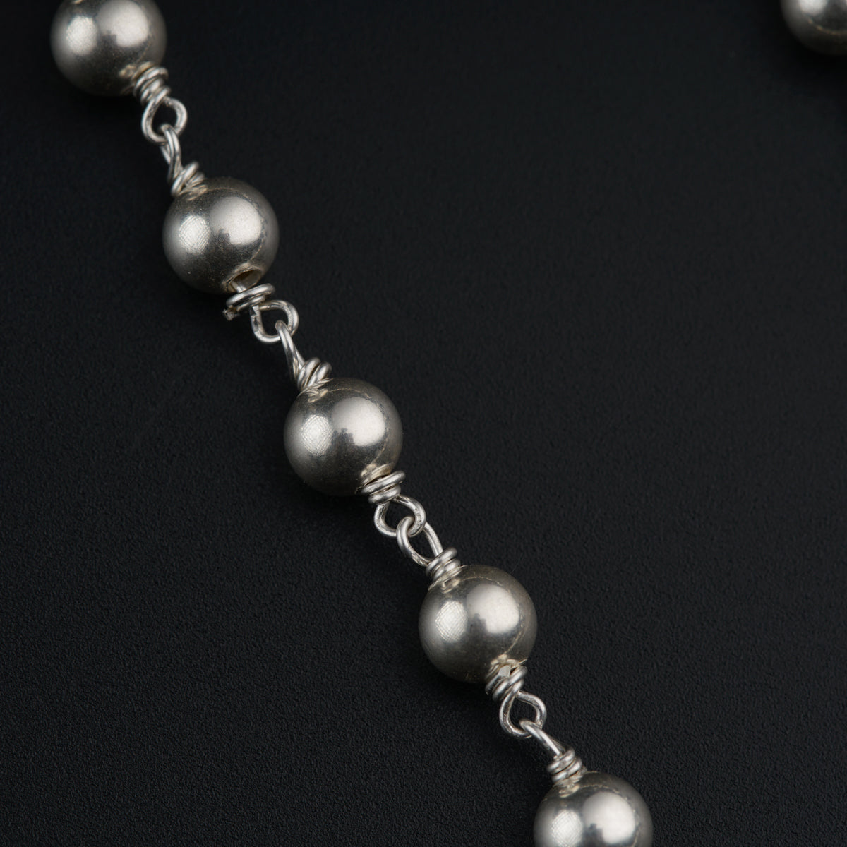 a close up of a chain with balls on it