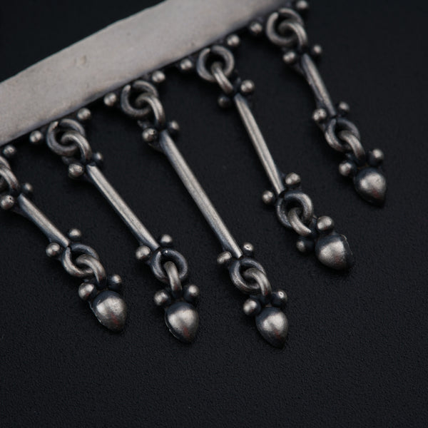 a close up of a knife with a bunch of beads on it