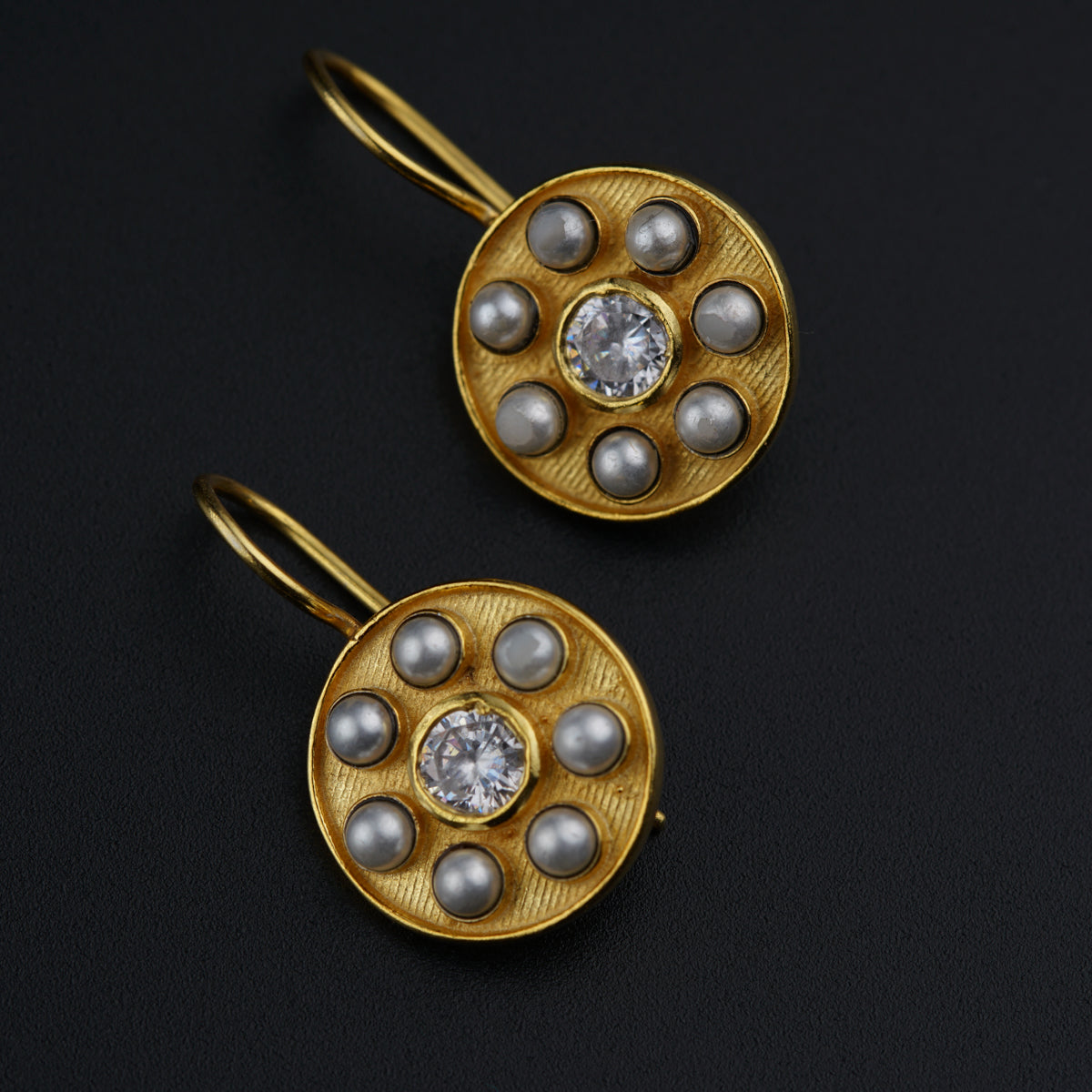 a pair of gold and pearl earrings