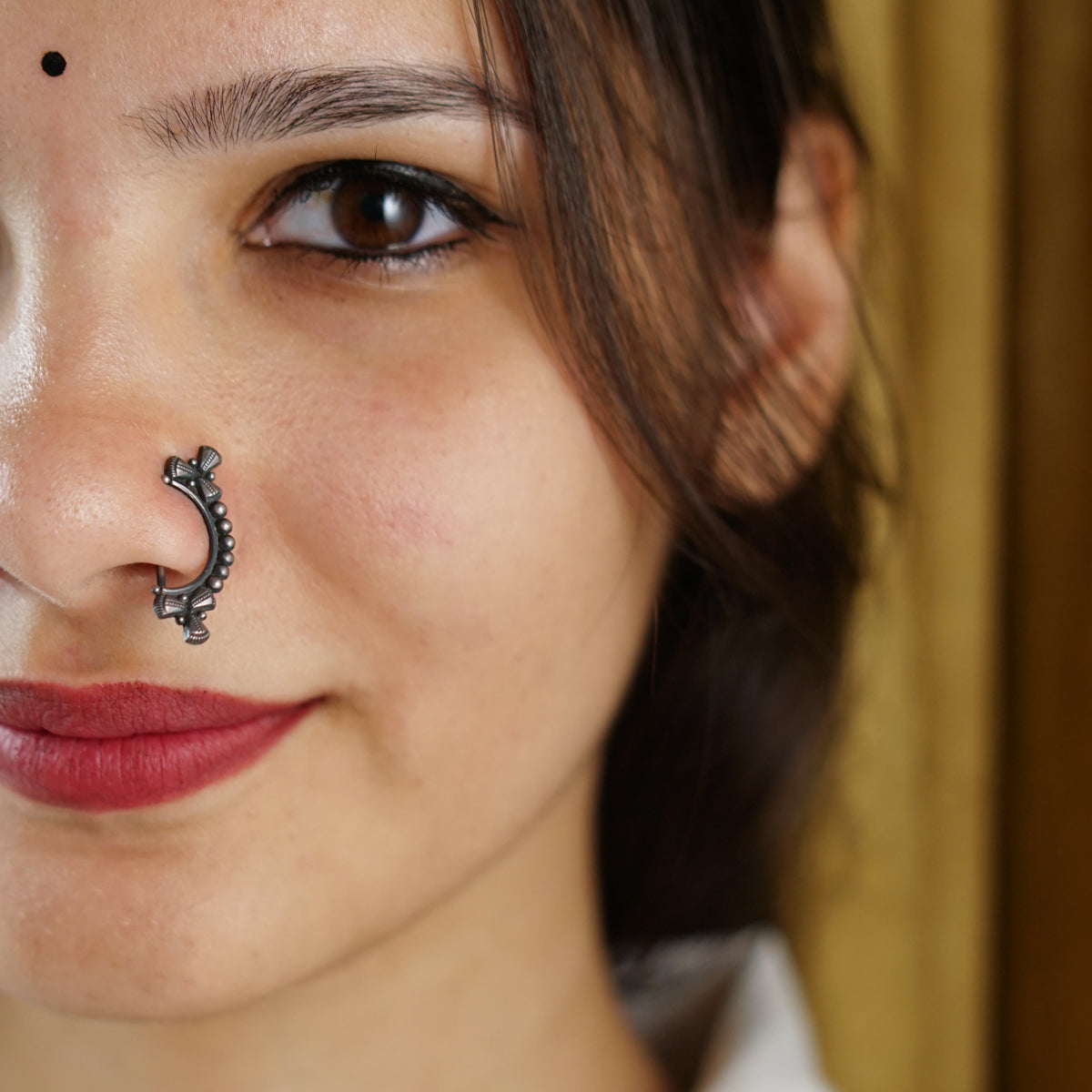 a close up of a woman with a nose piercing