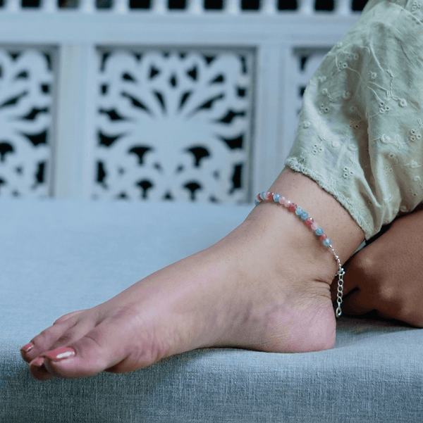 Silver anklet on fabric surface