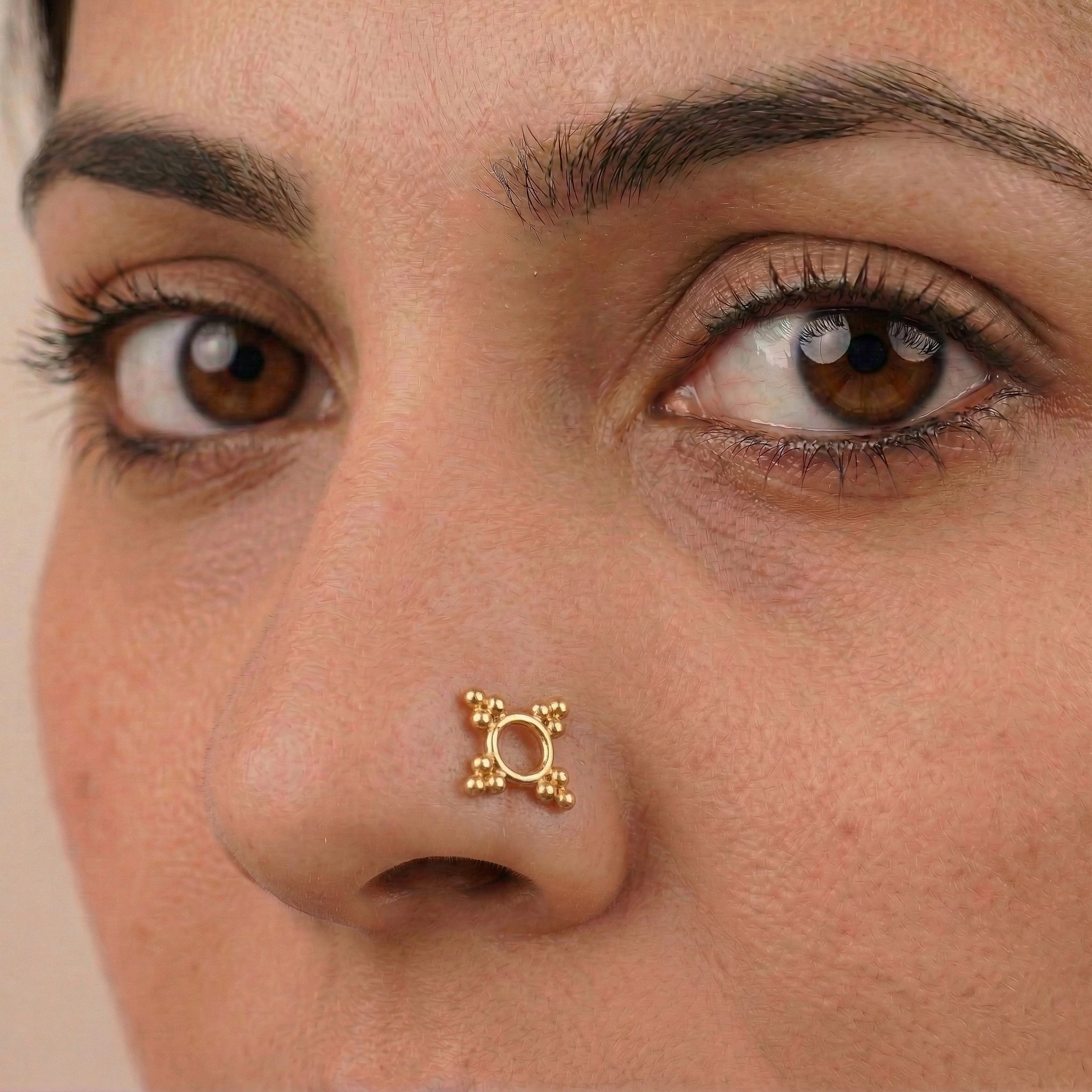 Gold plated nose pin on model's nose