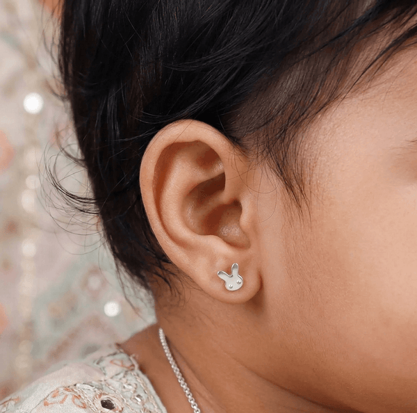 Woman wearing bunny stud earrings