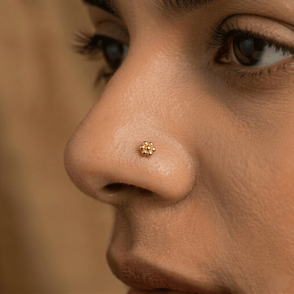 Close-up of a gold nose pin on skin