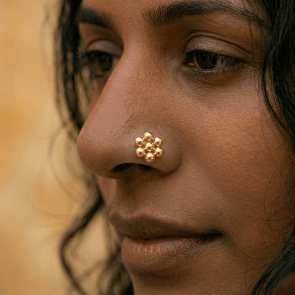 Gold floral nose pin on woman's nose