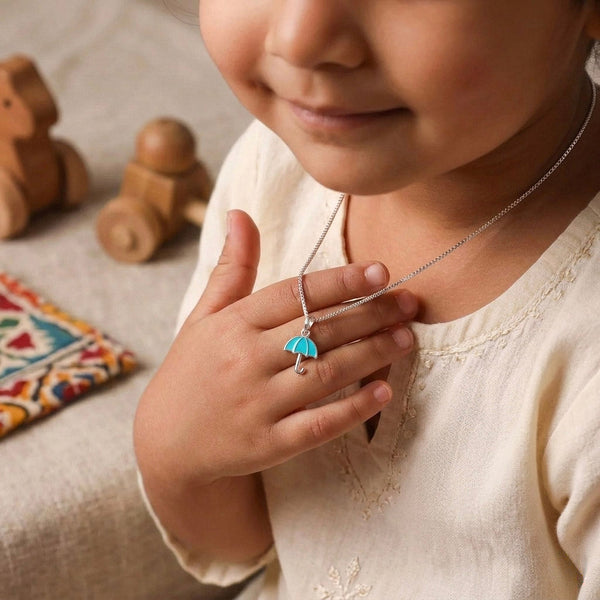 Child wearing silver umbrella necklace with chain