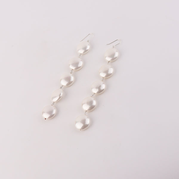 Pearl earrings with dangling pearls on white background