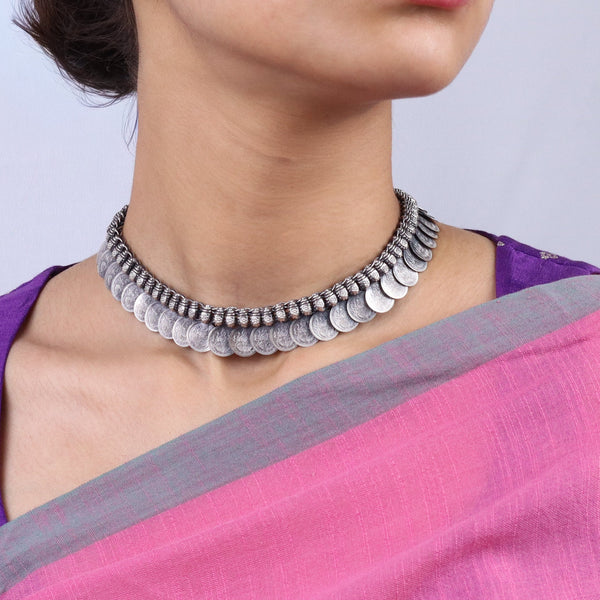 Close-up of woman wearing silver necklace and earrings