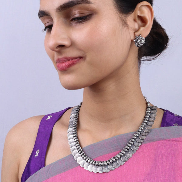 Woman wearing silver jewelry set with necklace and earrings