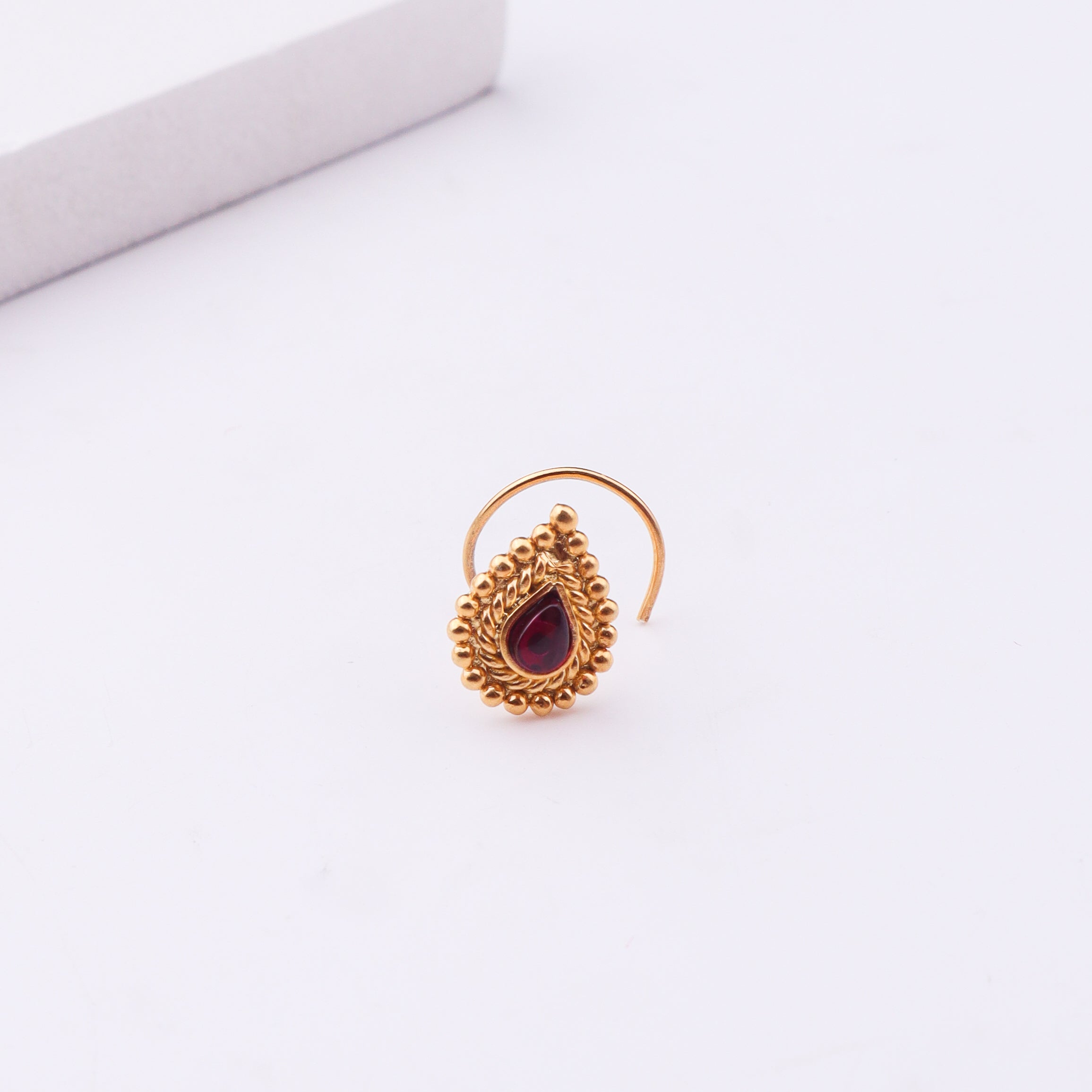 Gold-plated nose pin with pink stone and intricate design for pierced noses
