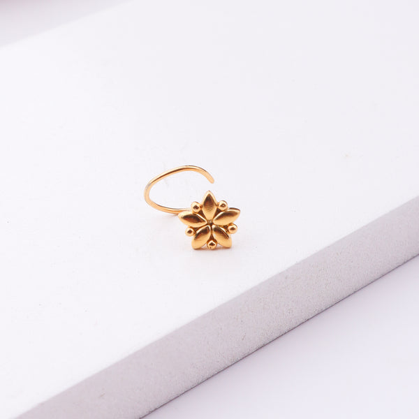 Gold floral nose pin on white background