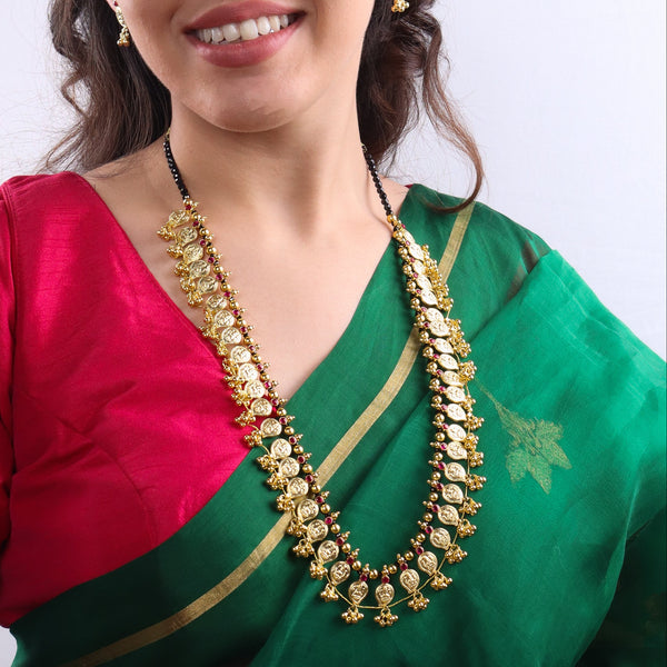 Traditional gold necklace with matching earrings on model