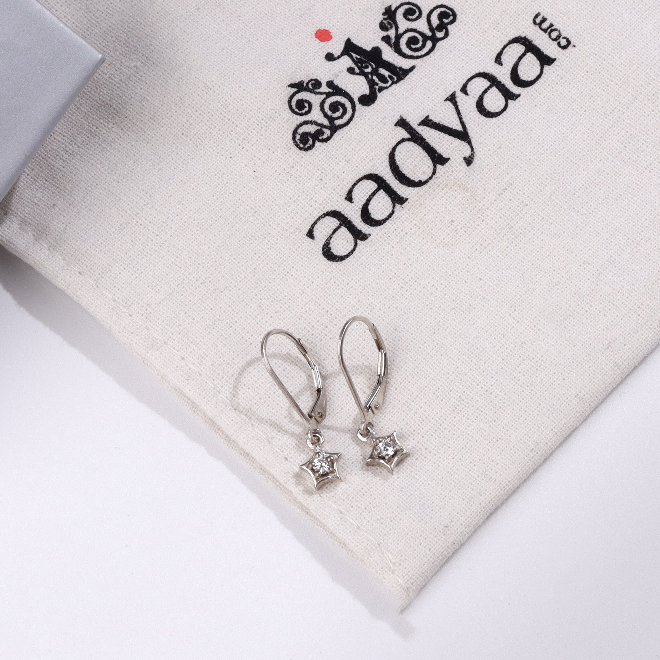 Silver star earrings with CZ stones on Aadyaa jewelry pouch