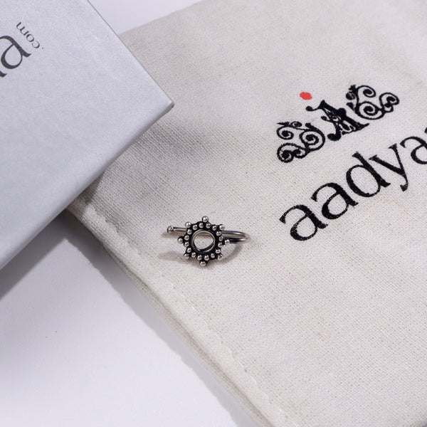Minimal silver nose pin with circular design on Aadyaa jewelry pouch