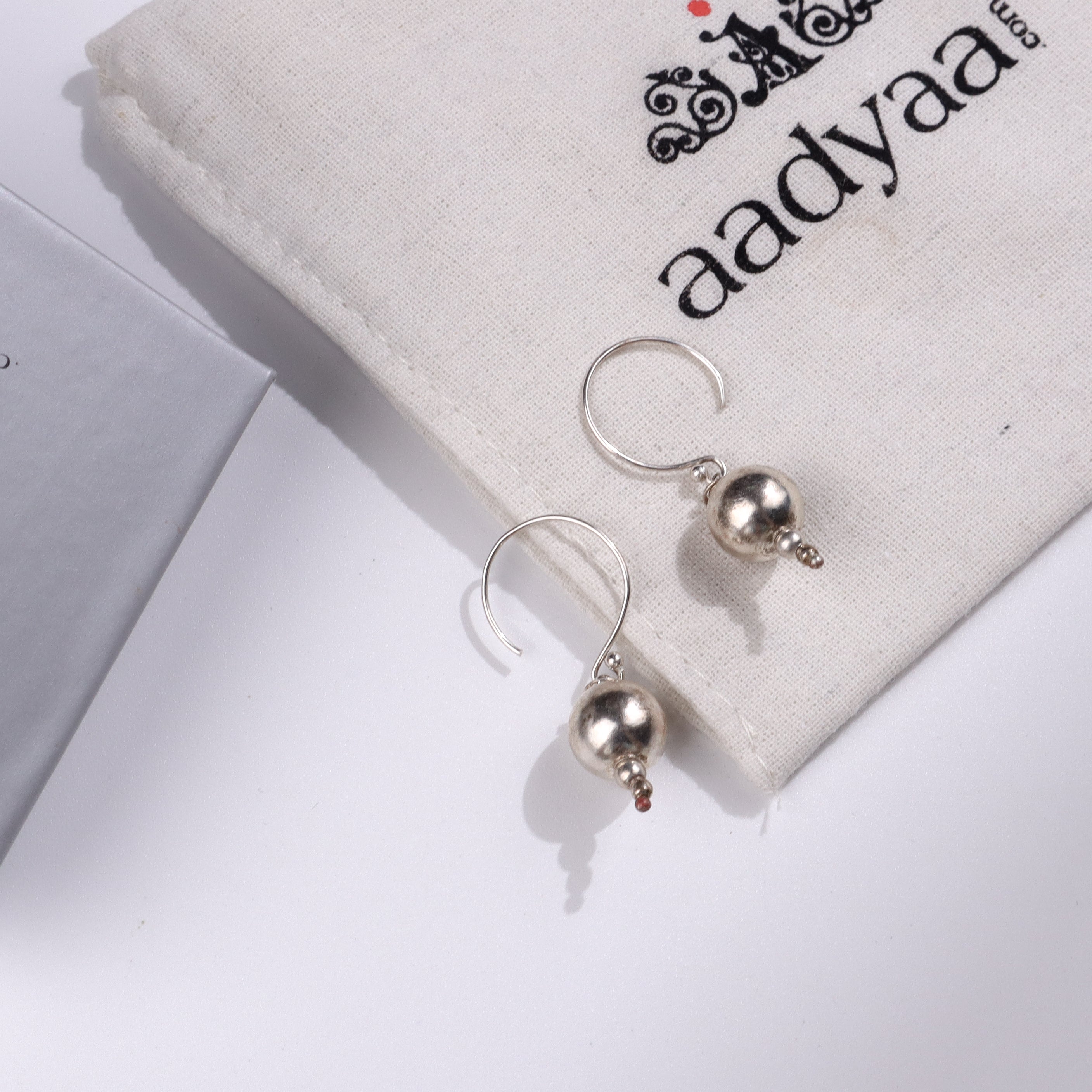 Silver bead earrings on fabric pouch for jewelry