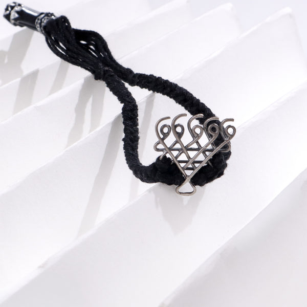 Silver Saraswati bracelet small with black thread on white background
