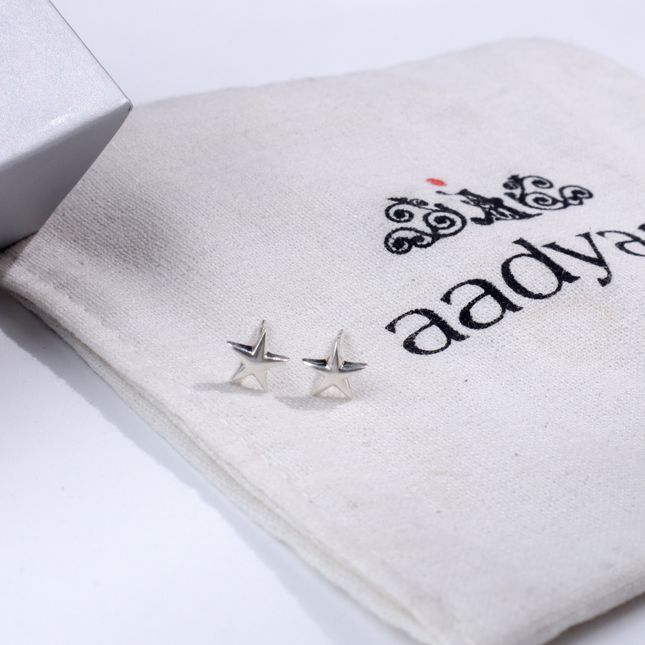 Silver starfish stud earrings on fabric pouch