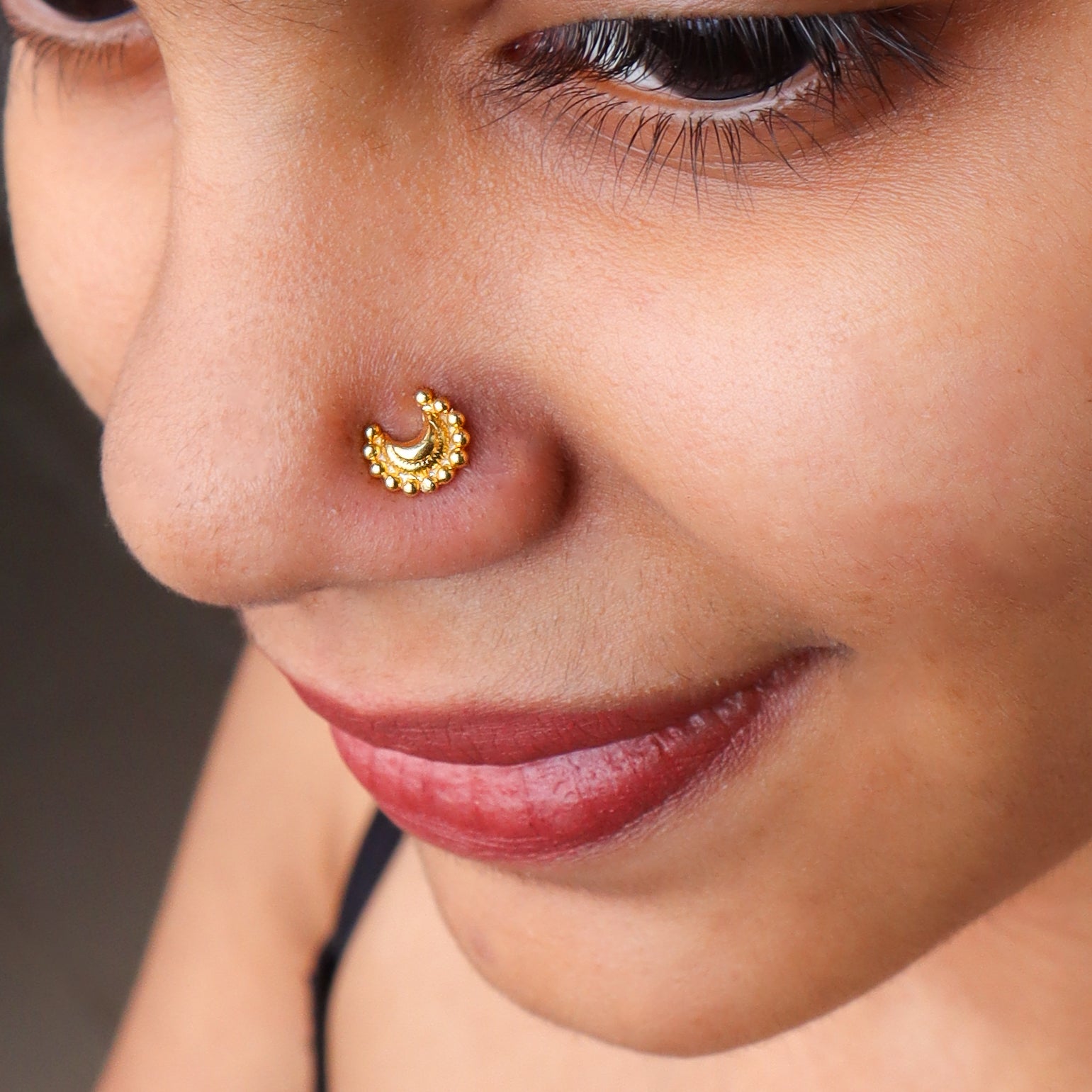 Gold plated crescent moon nose pin on pierced nose