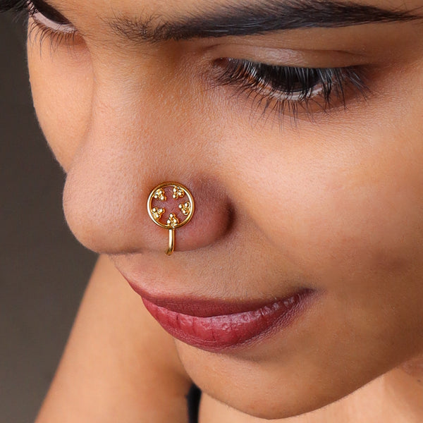 Gold nose pin with circular design and embedded stones