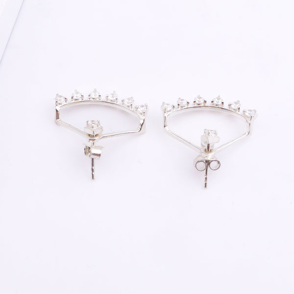 Silver hoop earrings with sparkling stones on white surface