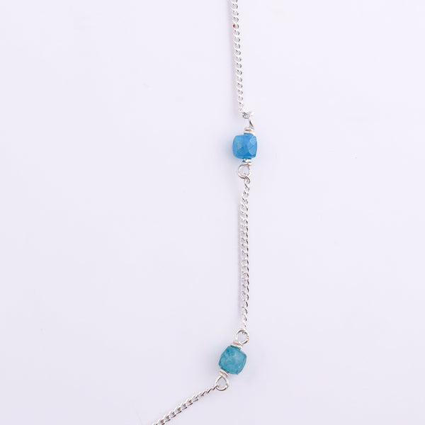 Silver chain with blue apatite gemstone on white background