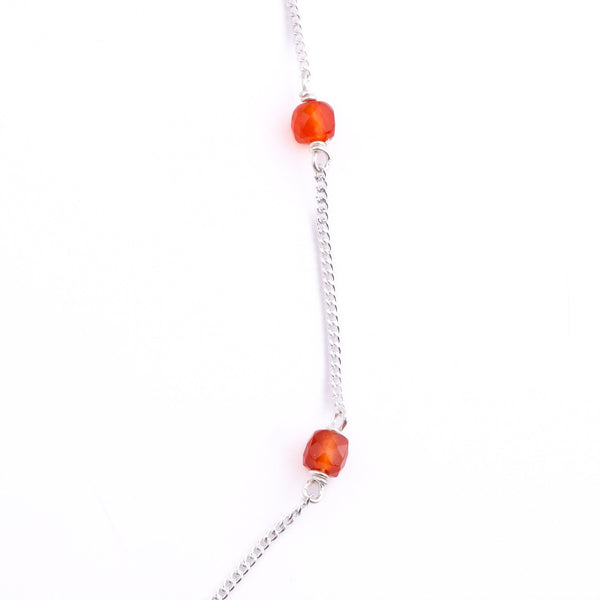 Silver chain with orange Carnelian beads on white background