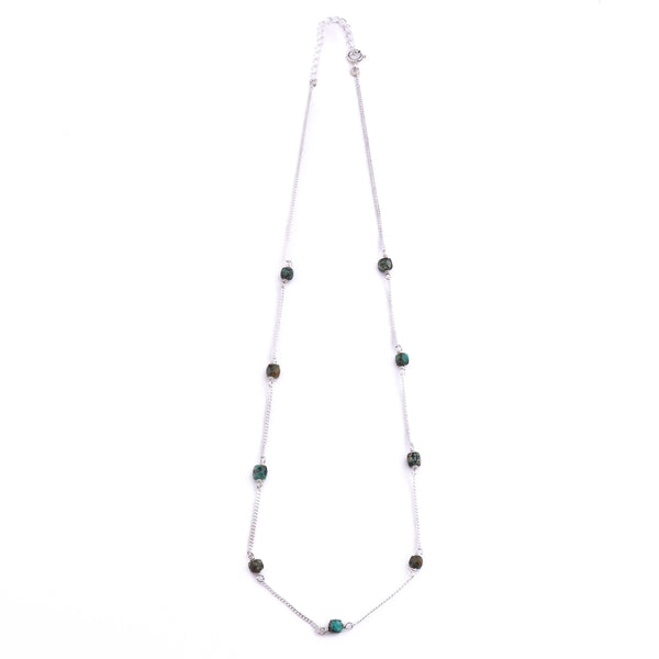 Silver chain with turquoise bead detail on white background