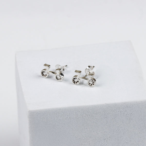 Silver bicycle earrings on display