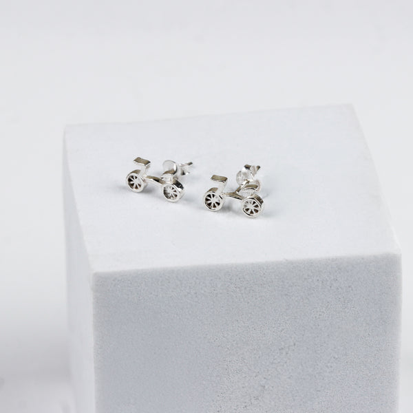 Silver bicycle-themed earrings on white surface